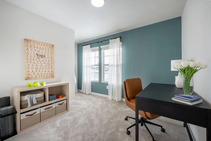 Bright, airy space featuring a chic home office with modern decor, stylish brown chair, and elegant tulip vase.