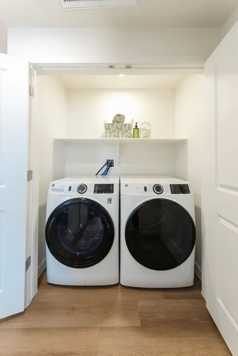 Modern laundry nook featuring sleek washer and dryer with stylish shelving for optimal organization.