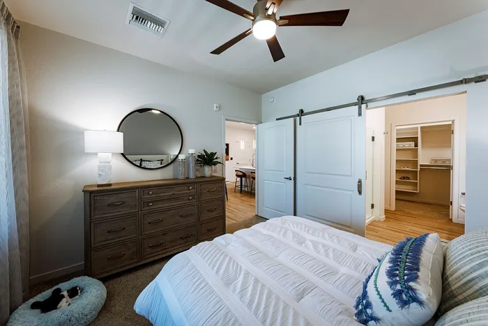 Chic bedroom featuring a cozy ambiance with elegant decor, sliding barn doors, and a spacious walk-in closet.
