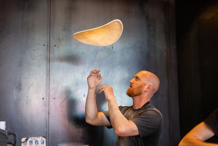 Image of man tossing pizza dough