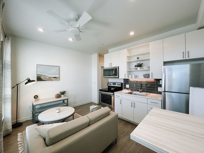 Colfax style unit living room area with kitchen and high-top bar table