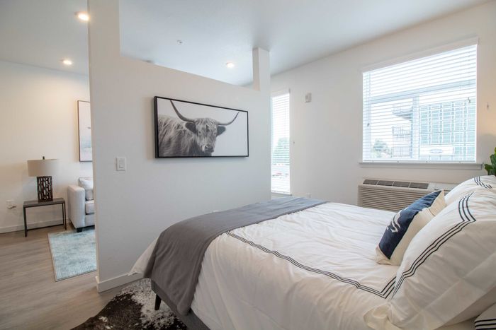 Bedroom with a small wall separating it from the living room