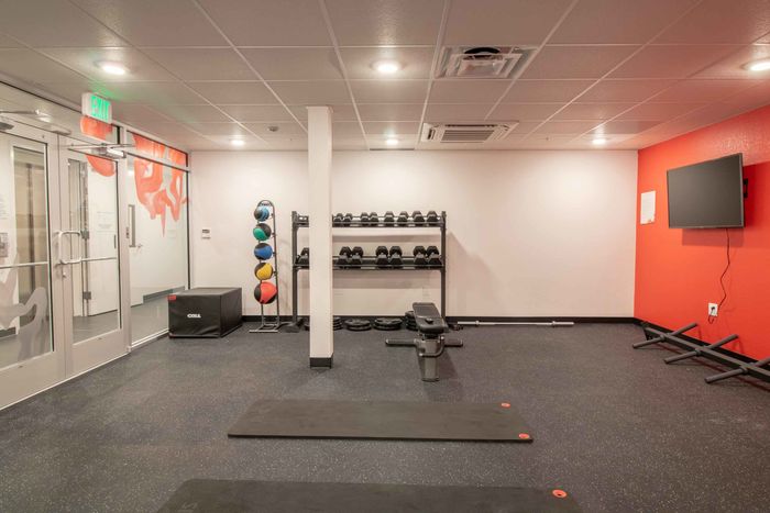 Fitness center with free weights, yoga mats and a TV
