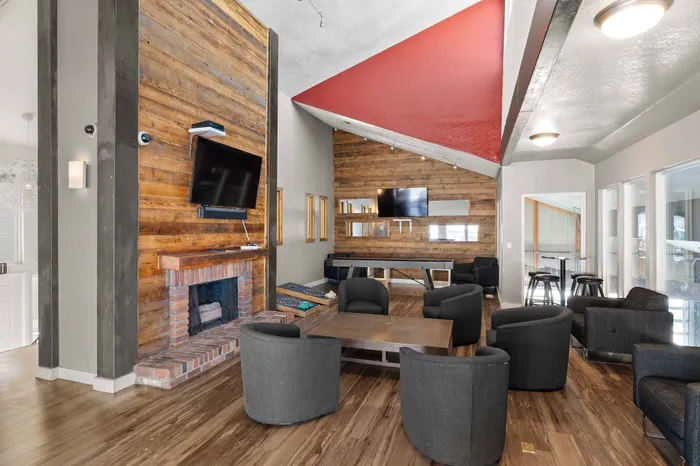 Inviting lounge area with cozy armchairs, a rustic fireplace, and modern TV setup, perfect for relaxation and entertainment.