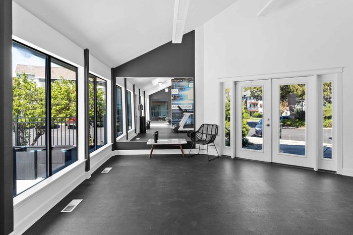 Bright fitness area with large windows, modern equipment, and sleek design offering a refreshing workout experience.