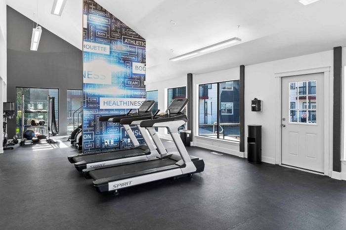 Bright and modern fitness center with treadmills, exercise equipment, and motivational wall decor.