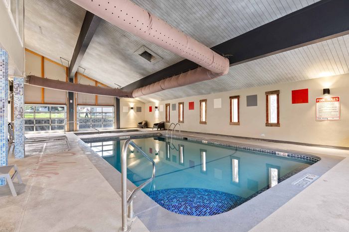 Inviting indoor swimming pool area with modern design and ample natural light, perfect for relaxation and leisure.