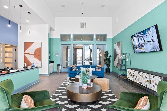 Stylishly decorated modern lounge with colorful seating, geometric patterns, and sleek furniture.
