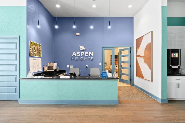 Modern reception area at Aspen Heights with vibrant blue walls, stylish decor, and welcoming ambiance.