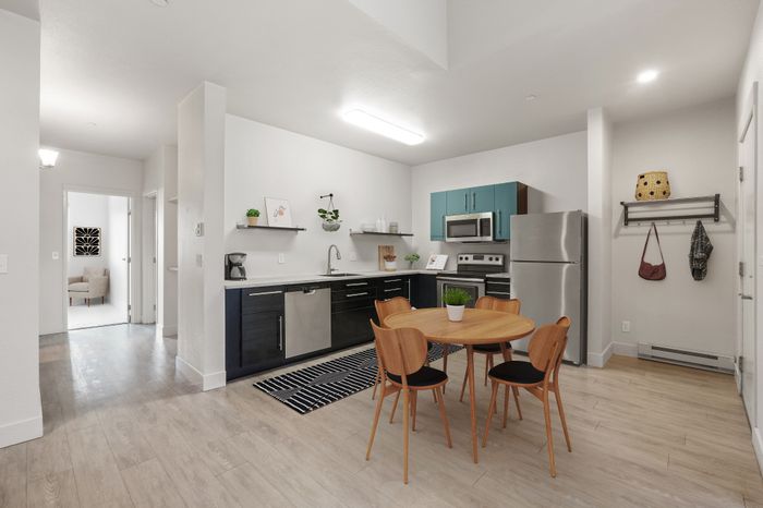 Modern apartment kitchen with sleek cabinets, stainless steel appliances, and inviting dining area.