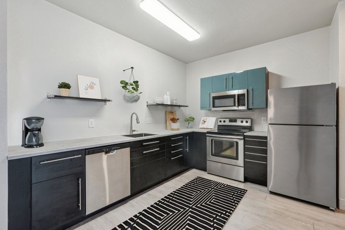 Modern kitchen with sleek stainless steel appliances, stylish cabinetry, and chic open shelving, offering a blend of function and contemporary design.