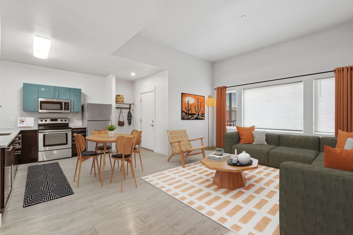 Modern open-concept living room and kitchen with stylish decor, including a chic dining set, vibrant artwork, and cozy seating area.
