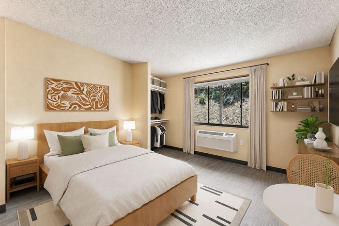 Inviting bedroom with modern furnishings, plush bedding, elegant art, natural light, and built-in storage.