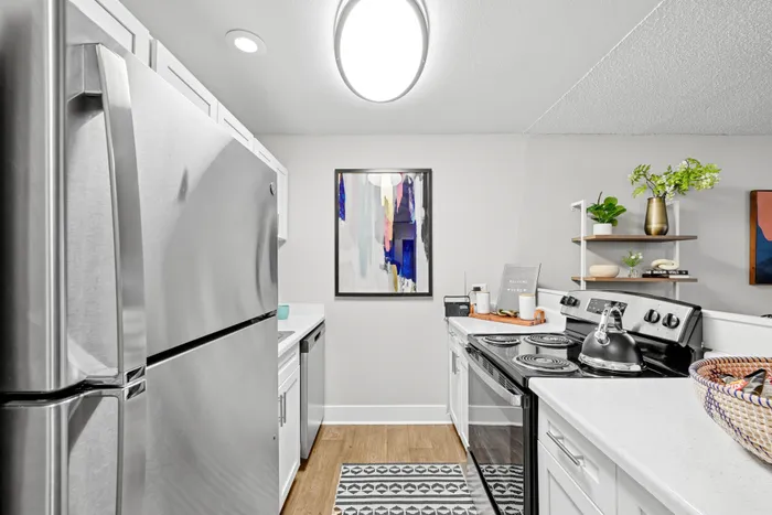 Modern kitchen featuring stainless steel appliances, elegant decor, and a sleek white finish with artistic accents.
