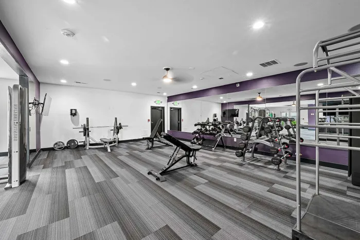 Modern fitness center with state-of-the-art equipment, featuring sleek design and ample workout space.