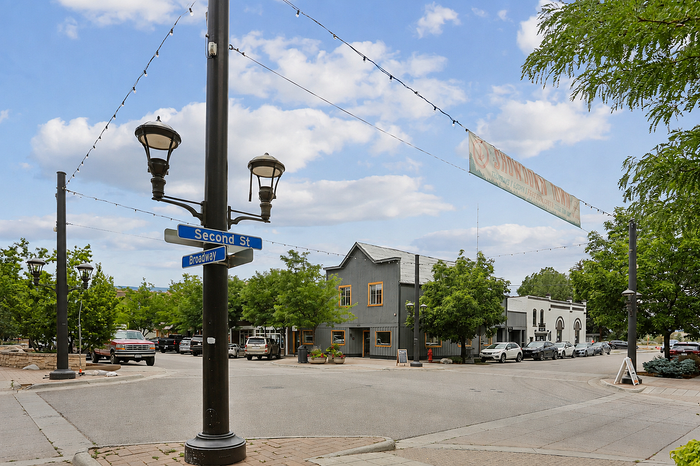 Charming street view at the intersection of Second St and Broadway, featuring quaint buildings and lush greenery under a bright blue sky.