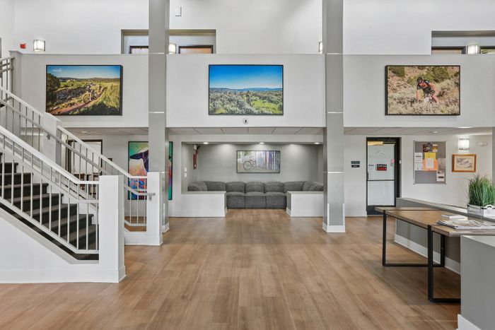 Modern apartment lobby with stylish decor, inviting seating area, and striking nature-themed artwork.