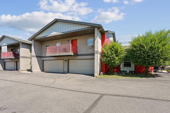 Charming duplex with modern design, featuring a vibrant red balcony perfect for relaxation, nestled in a serene neighborhood.