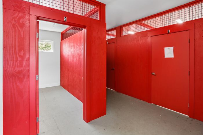 Vibrant modern storage unit with striking red doors and open-air design, perfect for secure and stylish organization.