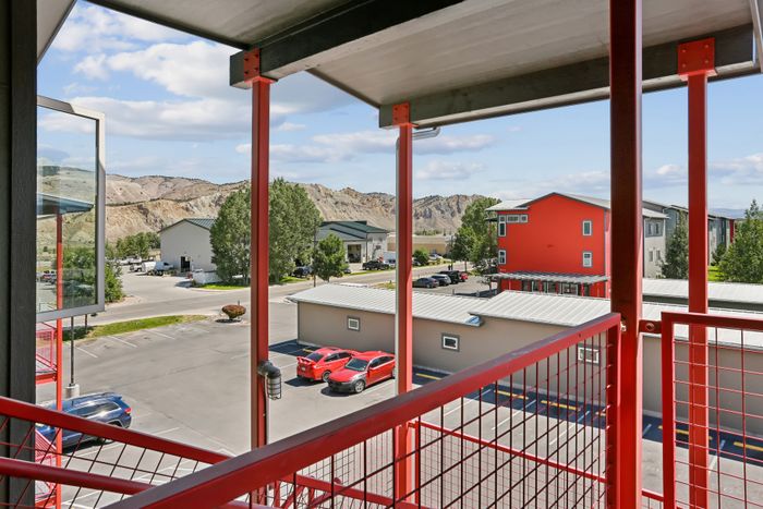 Charming balcony view showcasing a vibrant neighborhood with colorful buildings and stunning mountain backdrop.