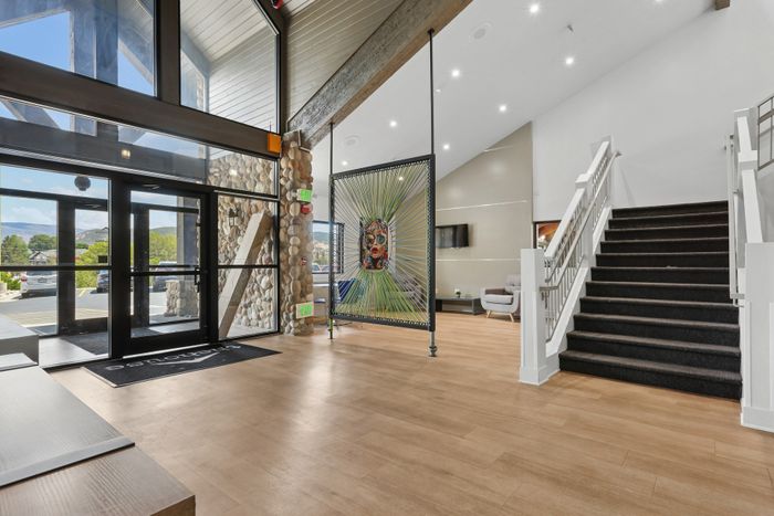 Modern apartment lobby with stunning mountain views, featuring sleek flooring, artistic decor, and inviting seating area.