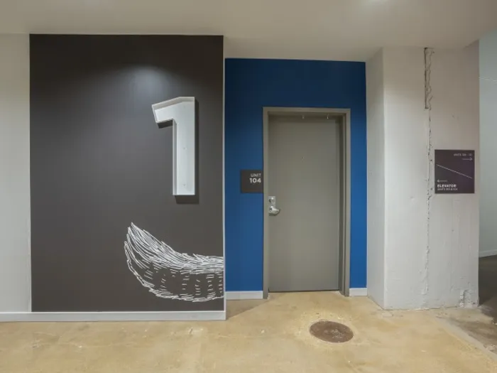 Apartment entrance with painted wing on the wall at The Fox Building.