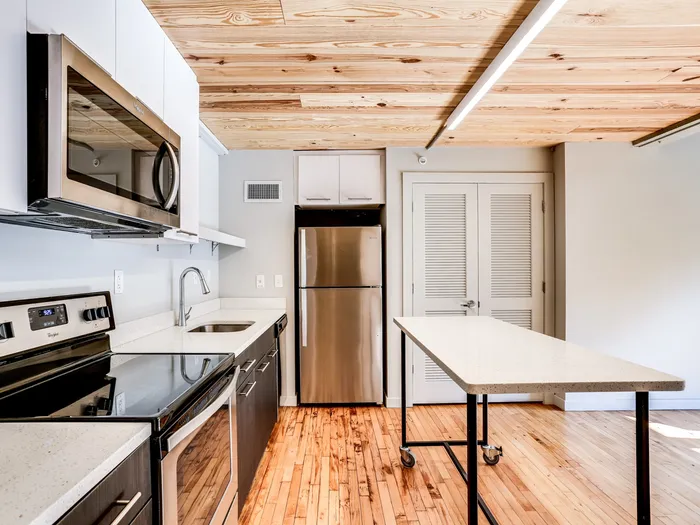 Modern kitchen with updated appliances and rolling table at The Fox Building.