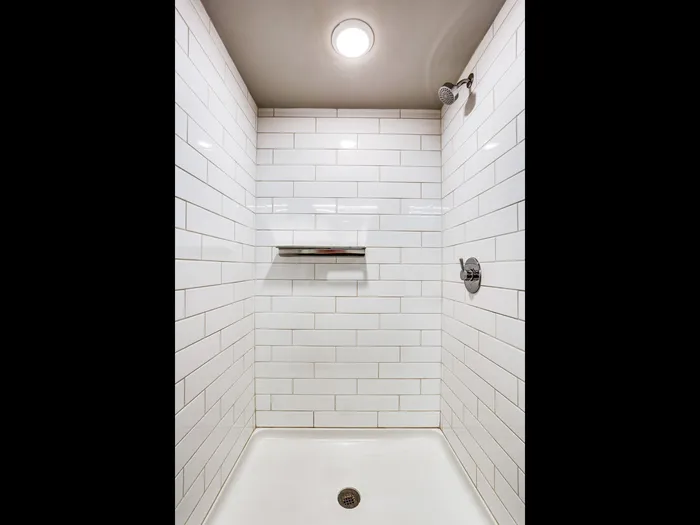 Beautiful white tile shower at The Fox Building.