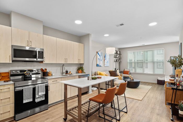 Modern kitchen with stainless steel appliances and wooden floors at Lofts at Yard 56.