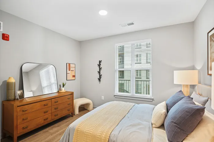 Bed, dresser, and mirror in a bedroom setting at Lofts at Yard 56 in Baltimore.