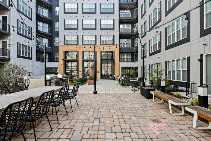 Lofts at Yard 56 courtyard with tables and chairs outside a building.