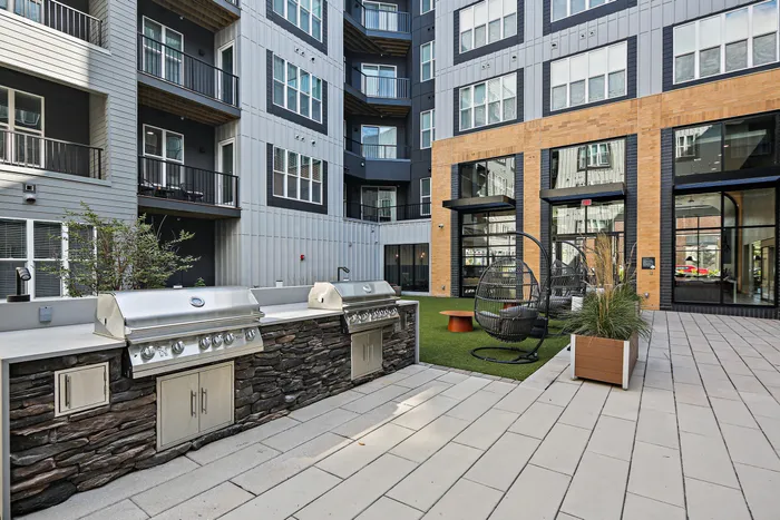 A courtyard at Lofts at Yard 56 with a grill and BBQ, perfect for outdoor gatherings and delicious meals.