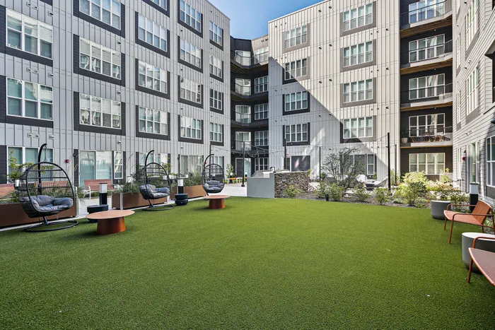 A spacious courtyard at Lofts at Yard 56 with a green lawn in front.