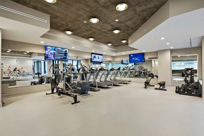 Lofts at Yard 56 fitness room with exercise gear and televisions.