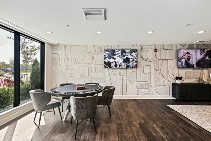 A spacious game lounge at Lofts at Yard 56 with a big flat screen TV as the focal point.