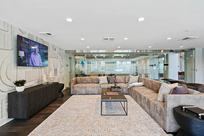 Comfortable game lounge at Lofts at Yard 56 featuring couch, table, and TV