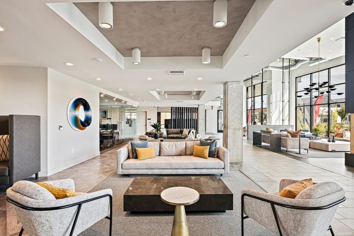 The lobby of Lofts at Yard 56 apartment building with large windows, welcoming natural light and a contemporary design.