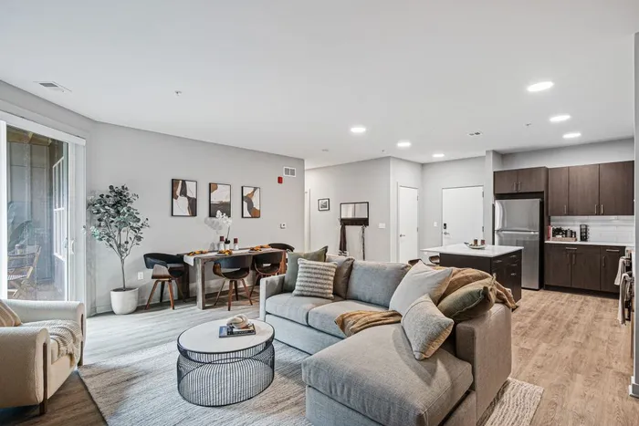 A bright and airy modern living room and kitchen in a two-bedroom apartment, designed for comfort and style at Lofts at Yard 56.