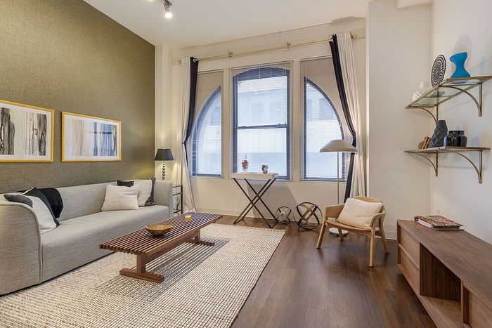 Contemporary living room with large windows, elegant decor, and cozy seating area.