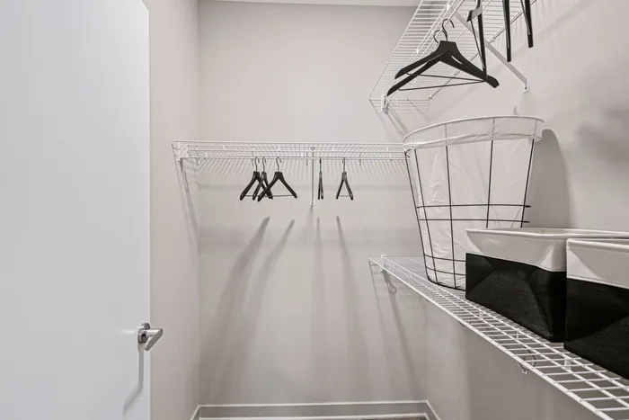 Inside Lofts at Yard 56 walk-in closet, showcasing stylish baskets and a variety of clothes arranged neatly.