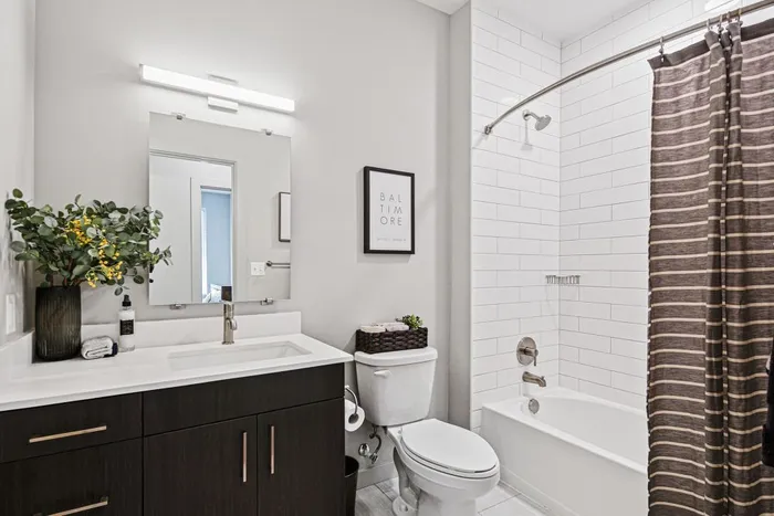 Lofts at Yard 56 secondary bathroom showcases a shower, toilet, and sink in a clean, functional layout.
