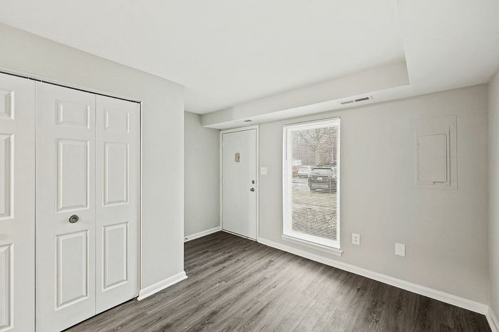 Inviting entryway with large window, modern flooring, and double-door closet.