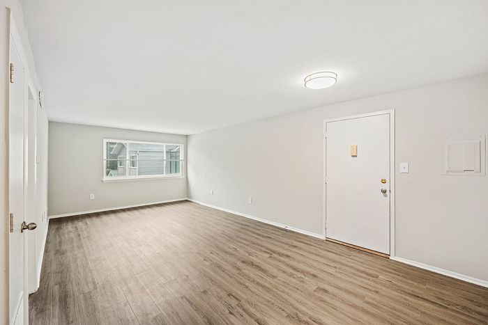 Bright and airy modern living room with wood flooring and a large window.