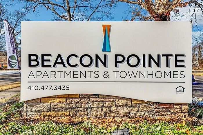Beacon Pointe Apartments & Townhomes sign with contact information displayed.