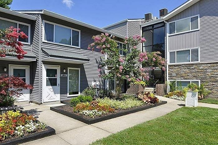 Modern apartment building with lush landscaping and vibrant flowers.