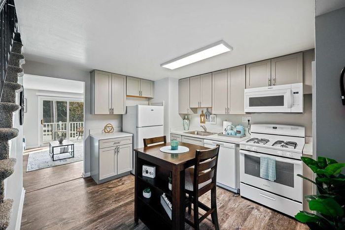 Charming apartment kitchen with modern appliances, cozy dining area, and inviting open layout to the bright living room.