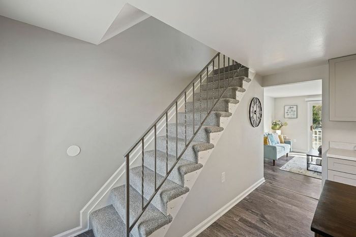 A stairway in a Rivers Gate townhome, connecting a cozy kitchen and a welcoming living room.