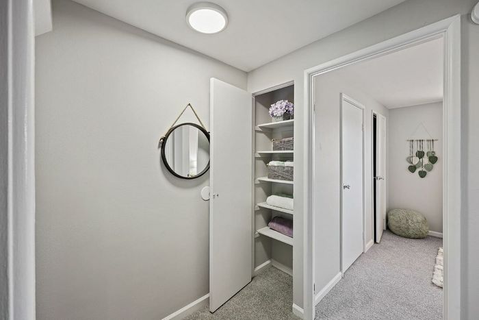 A hallway in Townhomes at Rivers Gate featuring a mirror and a closet, creating a welcoming entryway.