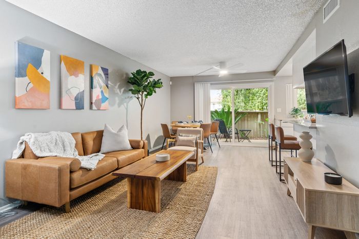 campus crossings riverside model unit living room with couches, coffee table, and tv