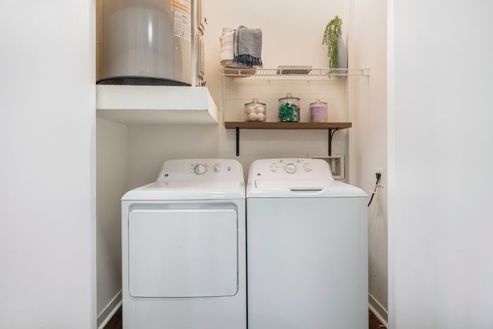 laundry room with washer, dryer, and hot water heater at campus crossings highland baton rouge